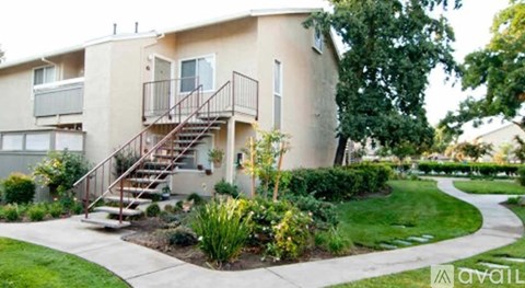 Apartments with a green lawn and a walkway in front.