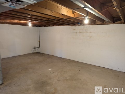 A room with a white wall and a concrete floor.