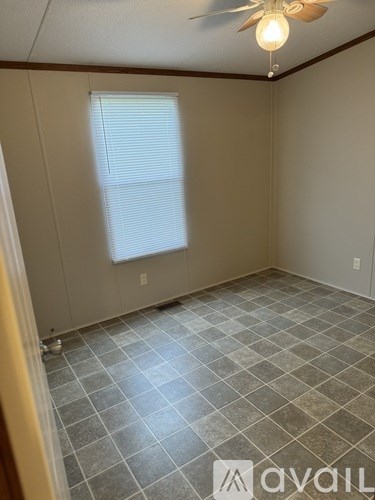 A room with a ceiling fan and a window with blinds.