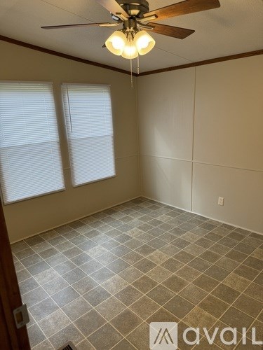 A room with a ceiling fan and tiled flooring.