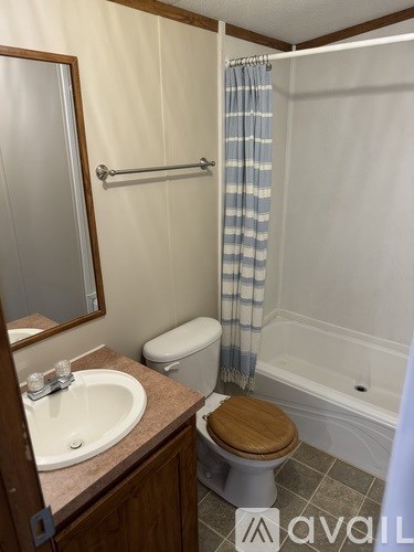 A bathroom with a toilet, sink, and shower.