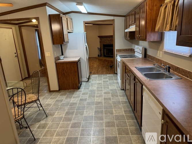 A kitchen with brown cabinets and a white fridge.
