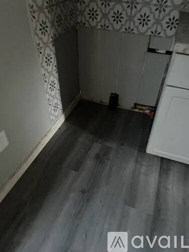 A room with a white cabinet and a grey floor.