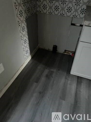 A room with a white cabinet and a grey floor.