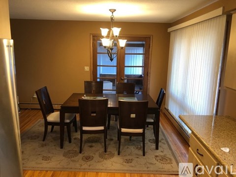 A dining room with a table and chairs.