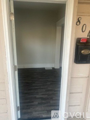 A white door with a black mailbox on the wall.