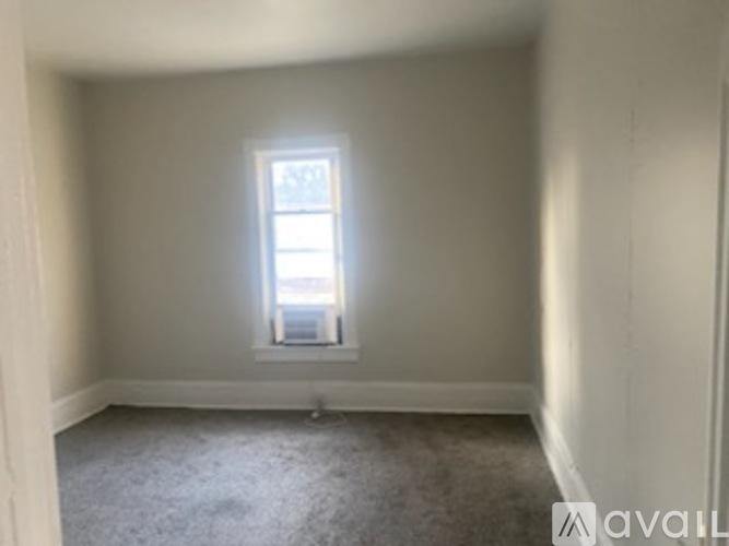 A room with a carpeted floor and a window.