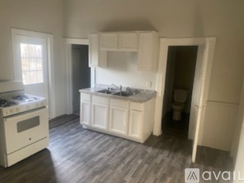 A kitchen with white appliances and cabinets.