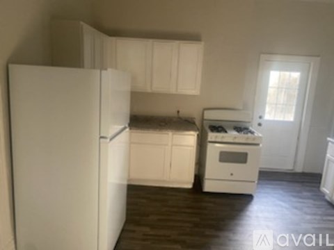 A kitchen with white appliances and cabinets.