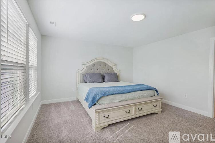 A bedroom with a large bed and a carpeted floor.