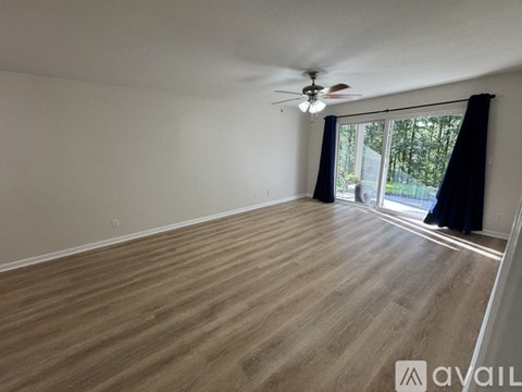 A room with wooden flooring and a ceiling fan.