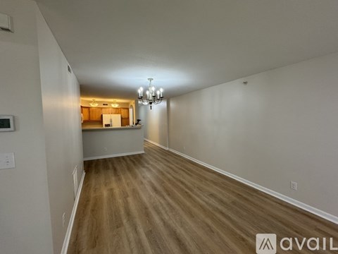 A room with wooden flooring and a chandelier.