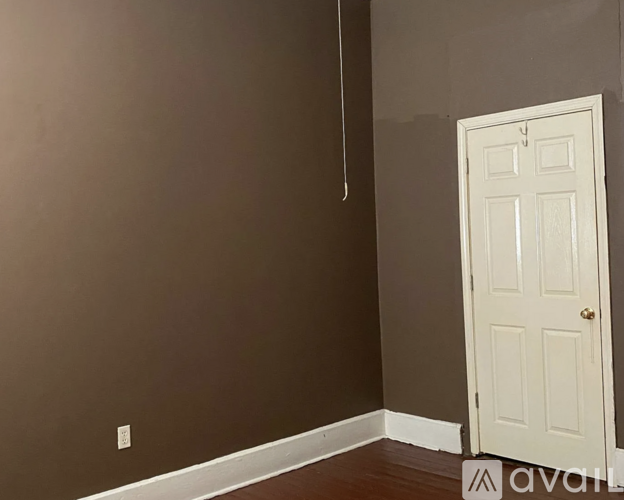 A room with a white door and a brown wall.
