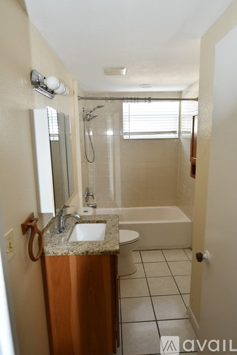 A bathroom with a sink, mirror, and bathtub.