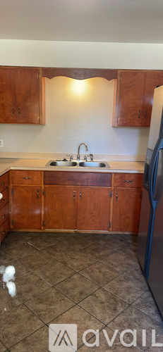 A kitchen with wooden cabinets and a tiled floor.