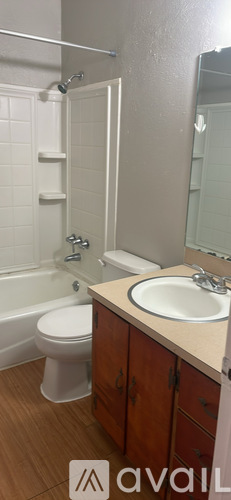 A bathroom with a toilet, sink, and mirror.