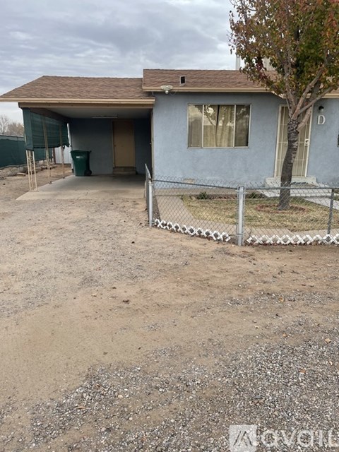A house with a brown roof and a tree in front of it.