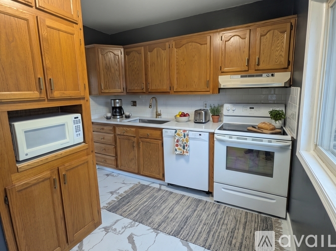 A kitchen with wooden cabinets and white appliances.