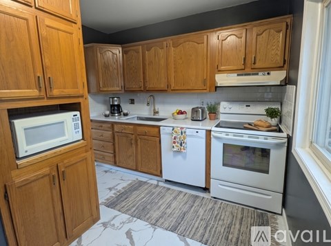 A kitchen with wooden cabinets and white appliances.
