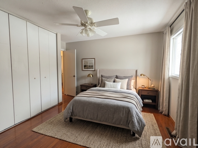 A bedroom with a large bed and a ceiling fan.