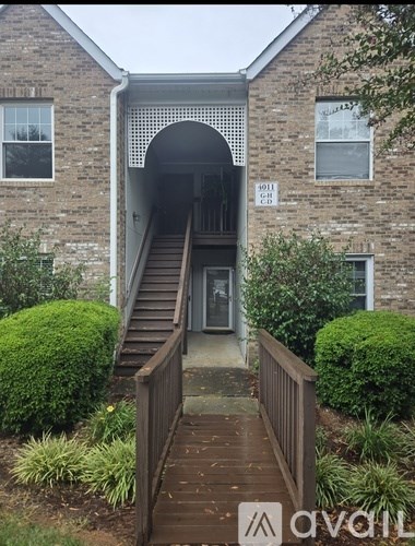 A brick building with a wooden walkway leading to a covered entrance.