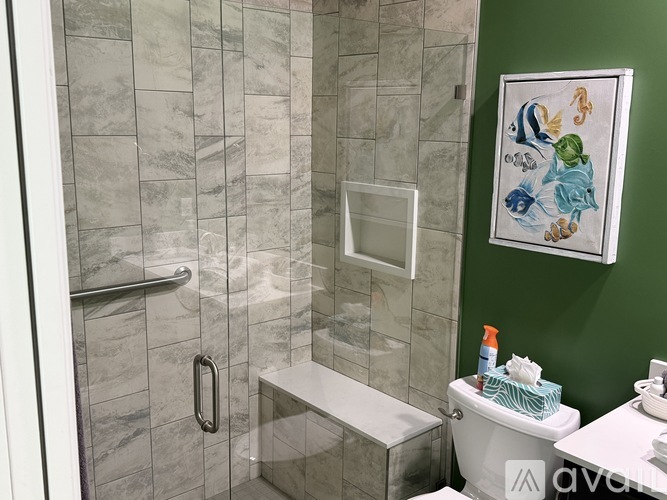 A bathroom with a green wall and a white toilet.
