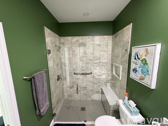 A bathroom with green walls and a white toilet.