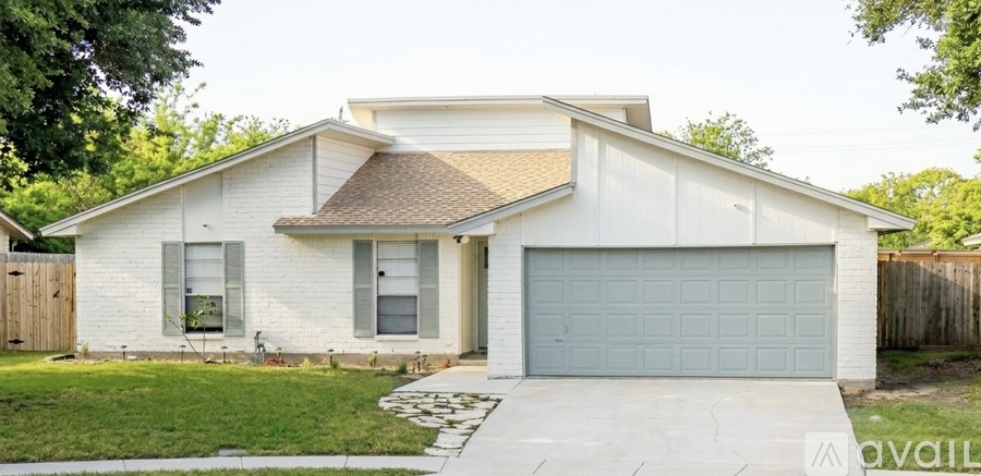 A white house with a grey garage door.