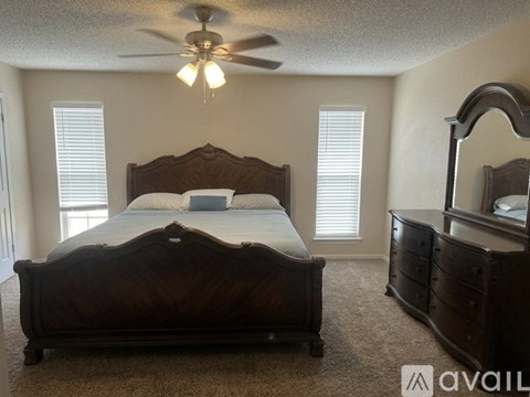 A bedroom with a large bed and a dresser.