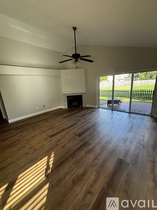 A room with a fireplace and a ceiling fan.