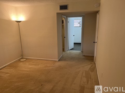 A room with a carpeted floor and a lamp.