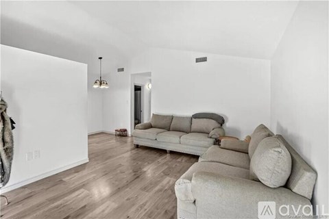 A living room with a grey couch and a wooden floor.
