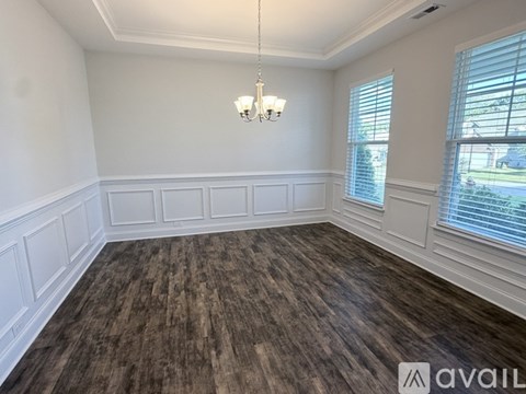 A room with wooden flooring and white walls.