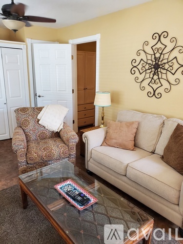 A living room with a couch, chair, and decorative wall art.