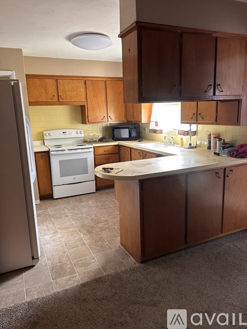 A kitchen with wooden cabinets and a white fridge.