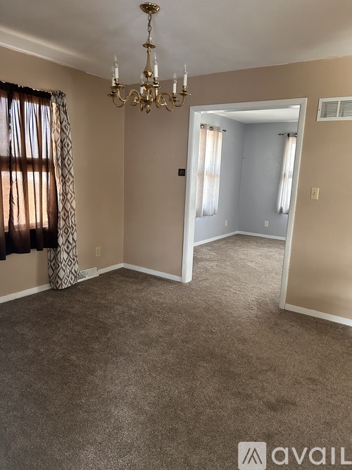 A room with a chandelier and a carpeted floor.