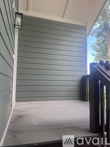 A balcony with a railing and a wall with horizontal siding.