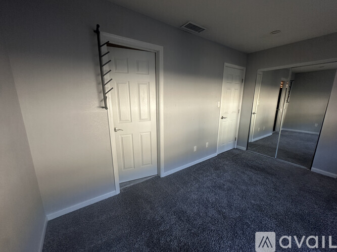 A room with a carpeted floor and a white door.