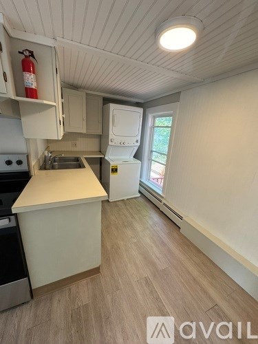 A kitchen with a white countertop and a stove top oven.