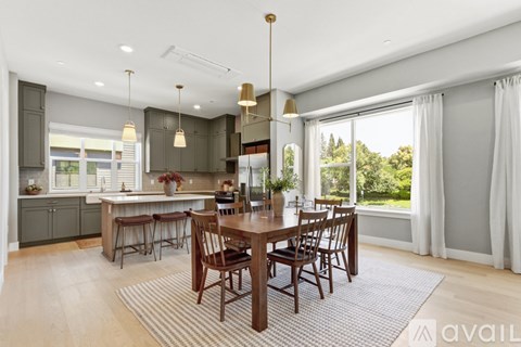 A modern kitchen with a dining table set for six.