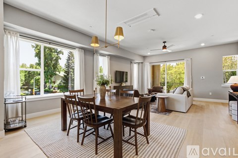 A dining room with a wooden table and chairs.