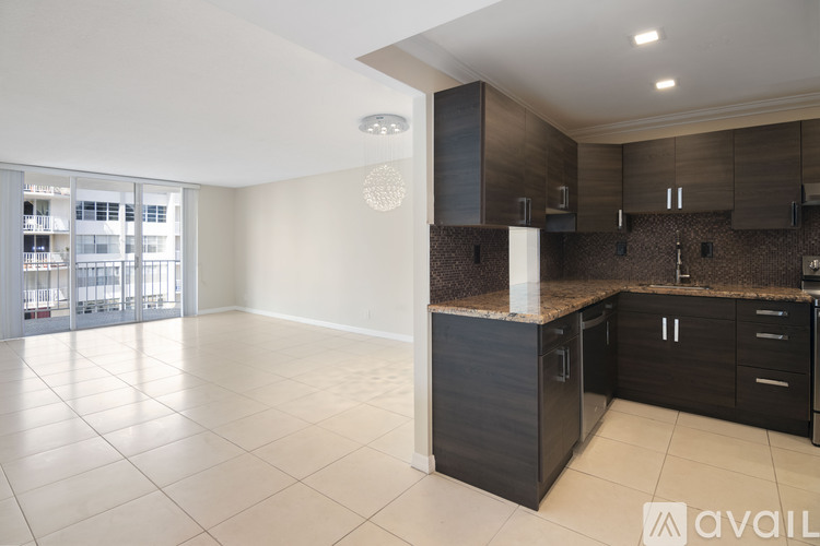 A spacious kitchen with dark brown cabinets and a white countertop.