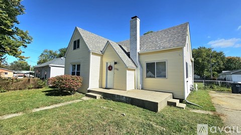 A house with a white exterior and a brown roof is for sale.