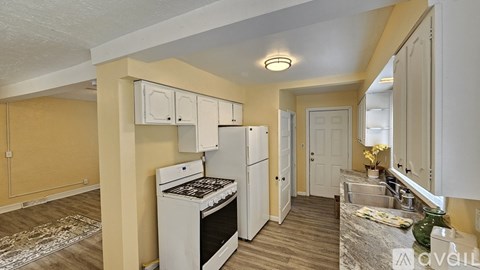A kitchen with a white stove and cabinets.