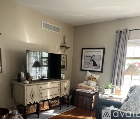 A living room with a television, a couch, and a coffee table.