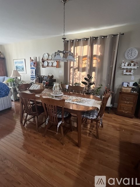 A dining room with a wooden table and chairs.