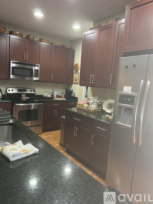 A kitchen with brown cabinets and a black countertop.