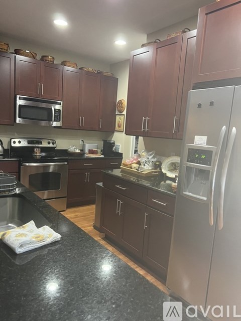A kitchen with brown cabinets and a black countertop.