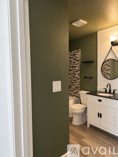 A bathroom with a toilet, sink, and mirror.