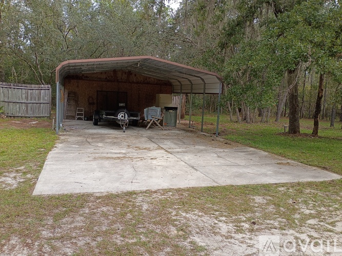 A car is parked in a garage with a metal roof.